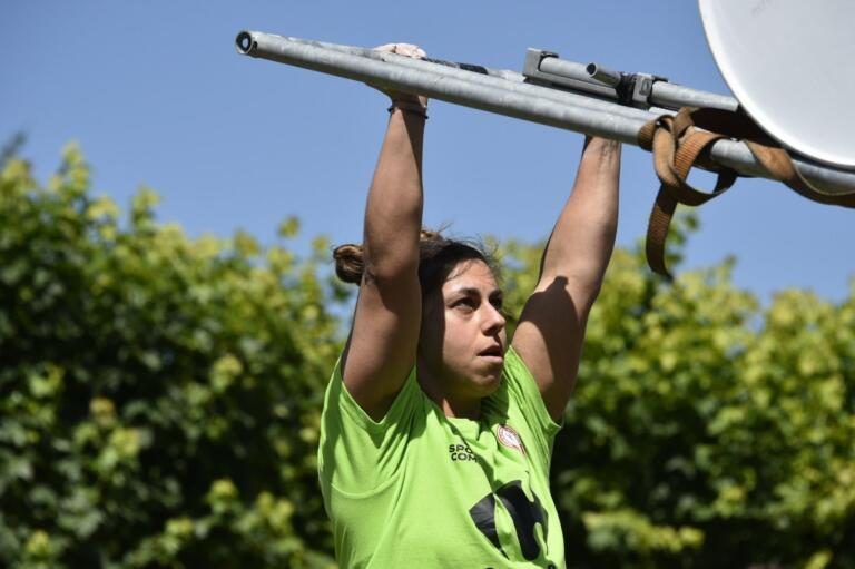 Lara soulevant une barre au-dessus de sa tête en compétition de force