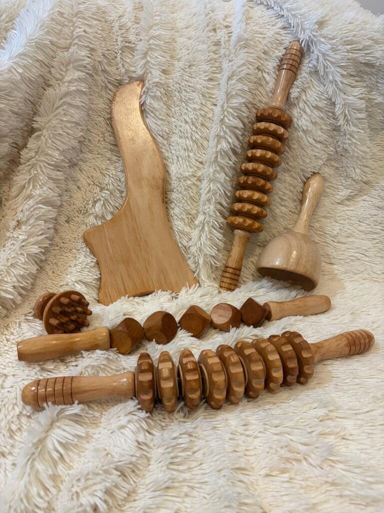 Rouleaux, ventouse et planche en bois de madérothérapie posés sur un plaid